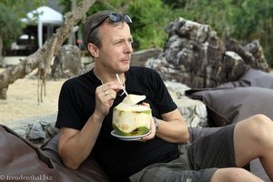 Lars genießt eine frische Kokosnuss am Strand vom Moonlight Bay Resort.