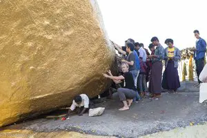 Lars klebt Blattgold auf den Goldenen Felsen von Kyaiktiyo