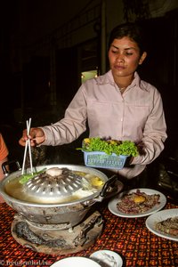 Die Bedienung hilft beim Cambodia BBQ in Siem Reap.
