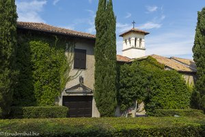 Grüne Hecken und ein Kirchturm im Garten von Schloss Duino