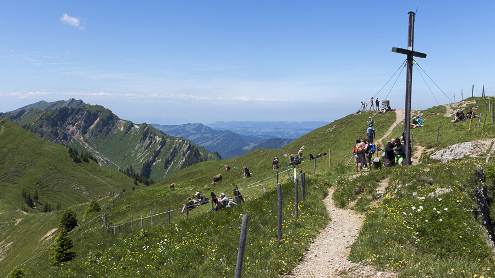 Wanderer beim Gipfelkreuz auf dem Stuiben im Allgäu