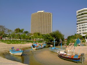 Fischerboote und Hotelbunker beim Cha-am Beach in Thailand