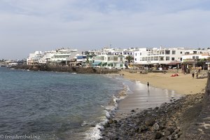 Blick über den kleinen Strand auf den Fischerort Playa Blanca