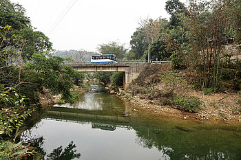 Reisebus auf einer Brücke über dem Bac Vong Fluss 