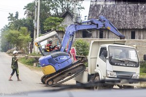 ein Bagger klettert in Luang Prabang auf einen LKW