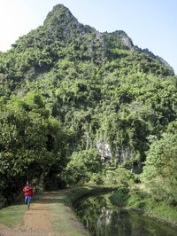 Spaziergang entlang einem Wasserlauf bei den Karstfelsen von Vang Vieng