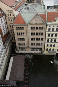 Blick hinab auf Restaurants und Hotels am Moldau-Ufer