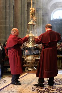 Priester leeren den Botafumeiro nach der Messe
