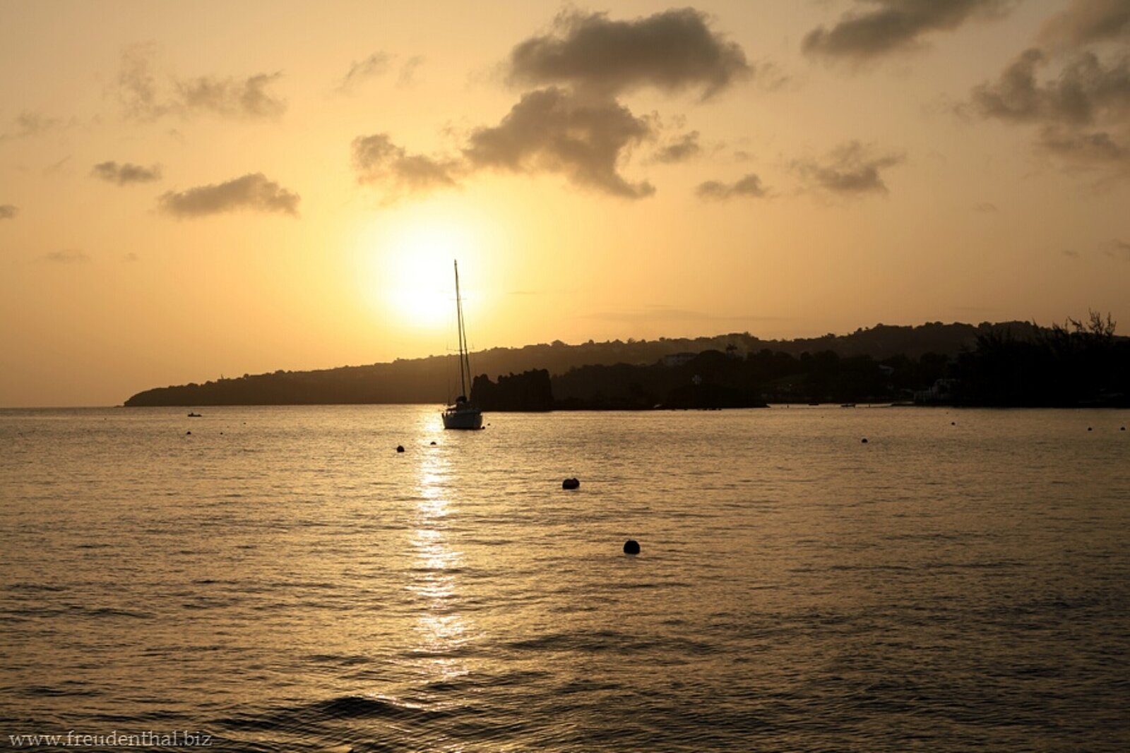 Segelboot vor einem Bilderbuch-Sonnenuntergang bei St. Vincent in der Karibik