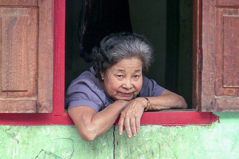 Lao Loum Frau schaut aus dem Fenster
