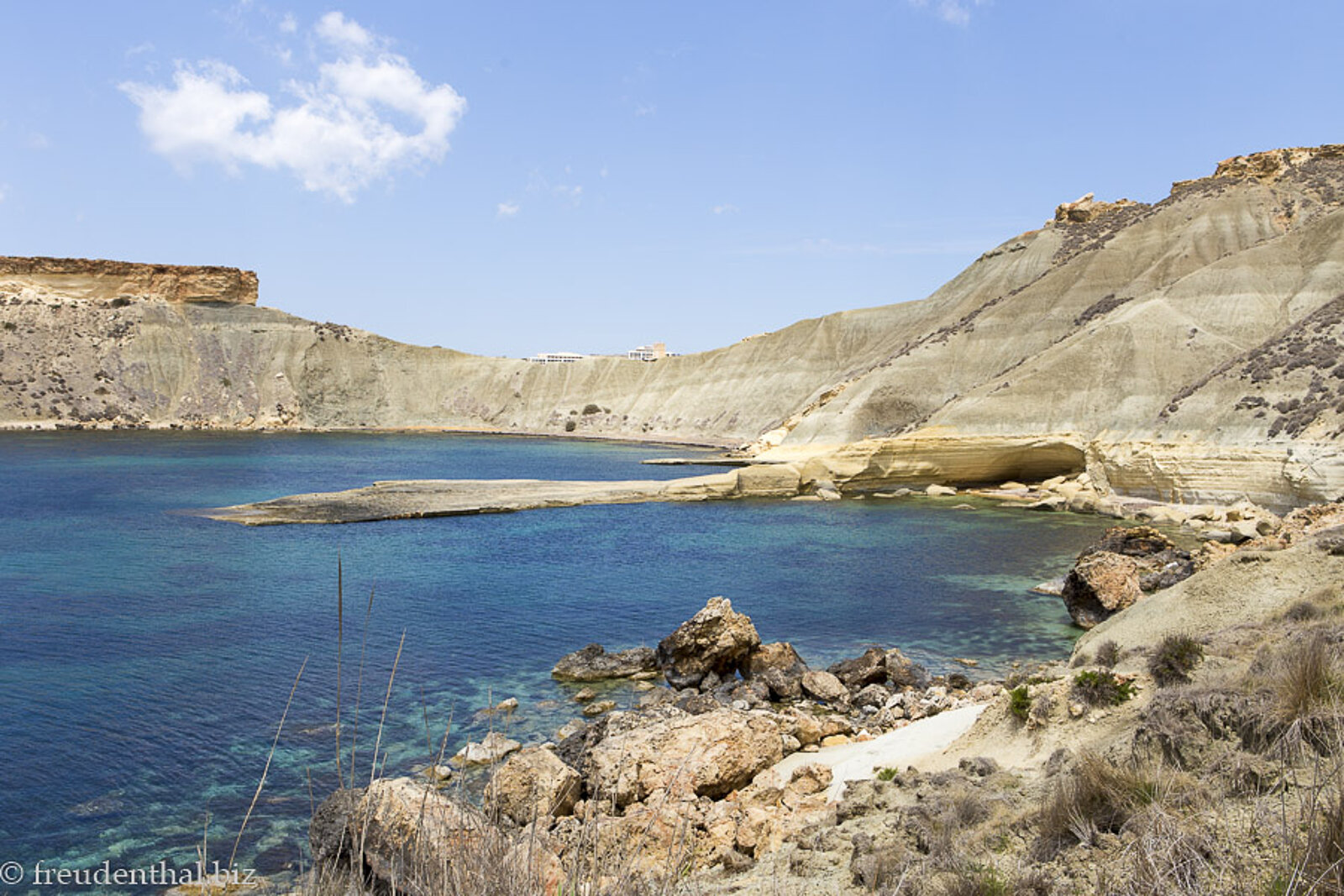 Sicht über blaues Wasser zur Felszunge in der Gnejna Bay auf Malta