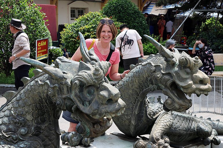 Annette bei den bronzenen Drachenskulpturen vor den Eingängen des Ben-Thanh-Marktes