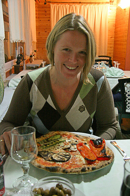 Annette freut sich über ihre große Pizza.