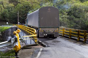 Schwere LKWs fahren über die schmalen Brücken des Rio Magdalena.