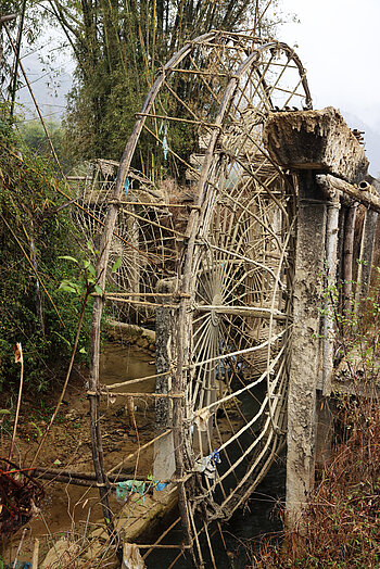 Ausgedientes Wasserrad am Fluss