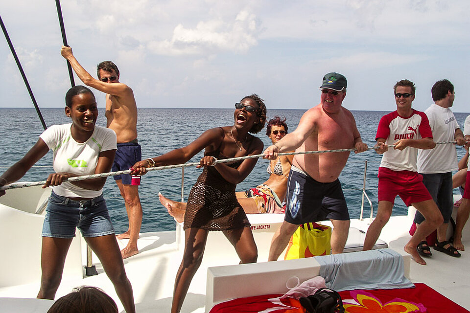 Gemeinsames Segel hochziehen auf dem Katamaran zur Isla Saona