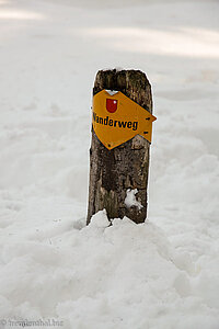 im Schnee versunkener Wegweiser