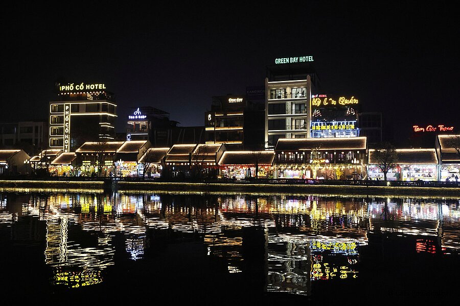 Die Flaniermeile von Hoa Lư spiegelt sich bei Nacht in einem Kanal.