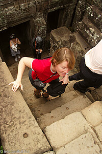 Anne klettert auf die dritte Ebene des Bayon in Angkor Thom.