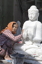 Frau beim plank Polieren der Buddhafigur