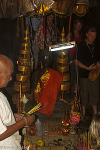 Ein Mönch im Tempel Bayon verteilt Räucherstäbchen.