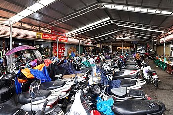 Motorroller reihen sich in einer Halle mit Einkaufsständen in Lang Son, Vietnam
