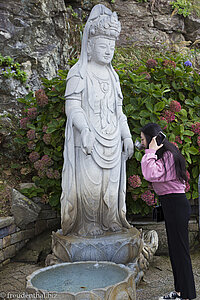 Koreanerin trinkt aus dem Brunnen des Avalokiteshvara