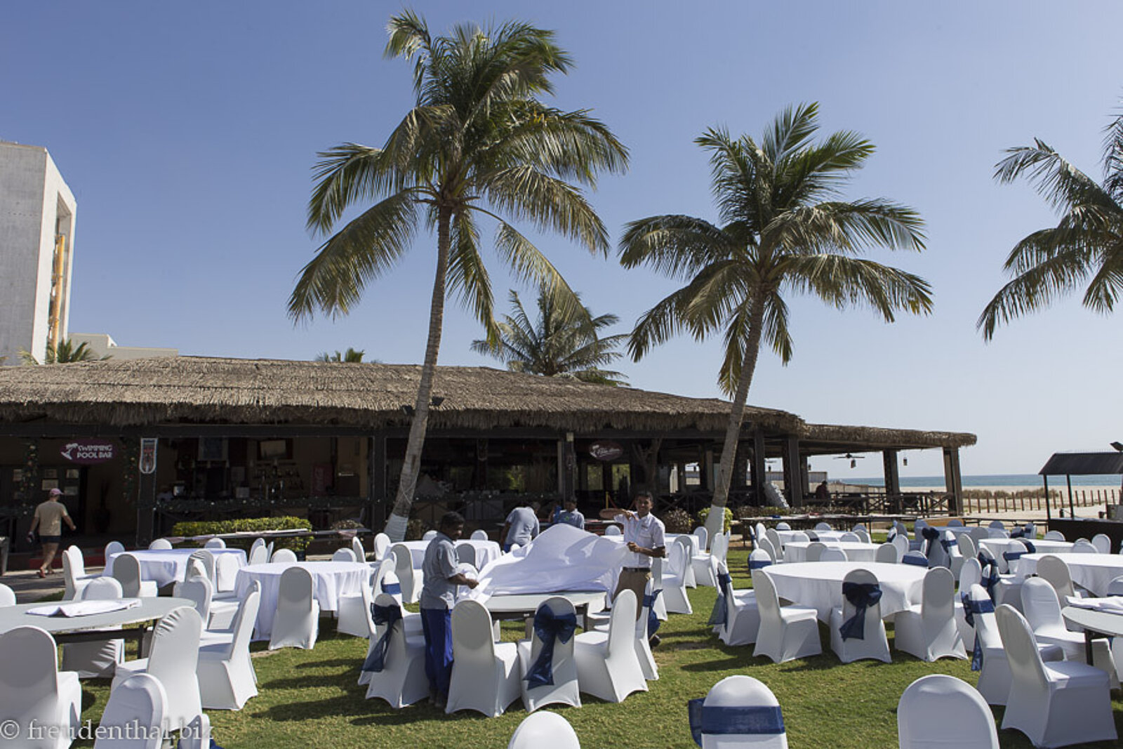 Mit weißen Decken eingehüllte Tische im Palmengarten im Hilton Salalah, Oman