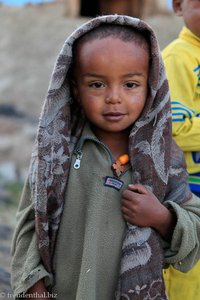 amharischer Junge in Äthiopien freut sich über Kleidung