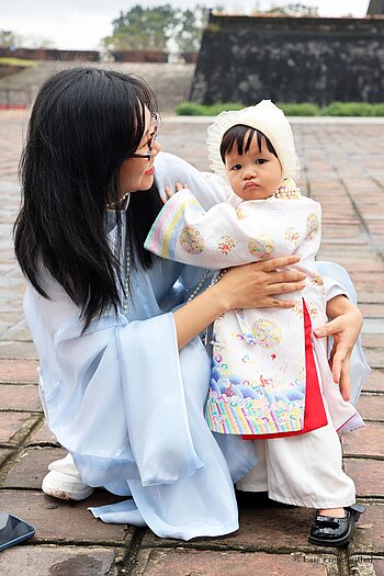 traditionell gekleidete vietnamesische Mutter mit ihrem Kind in der Zitadelle von Hué